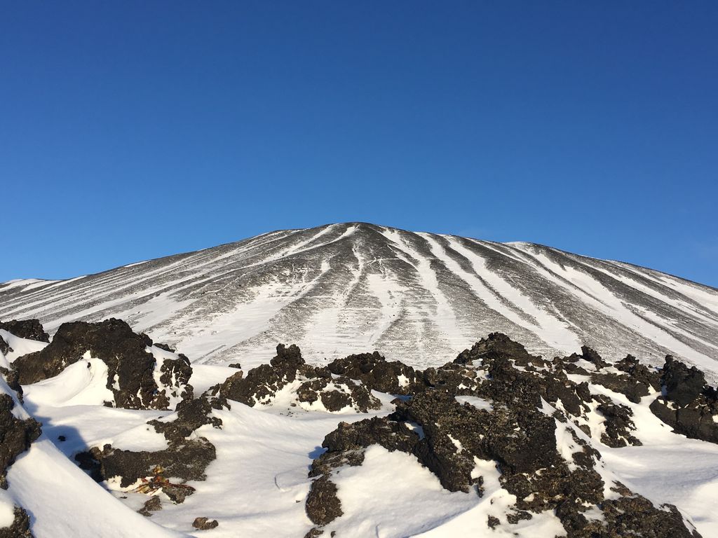 éruptions volcaniques en Islande : le cratère Hverfjall à l'arrière d'un champ de lave